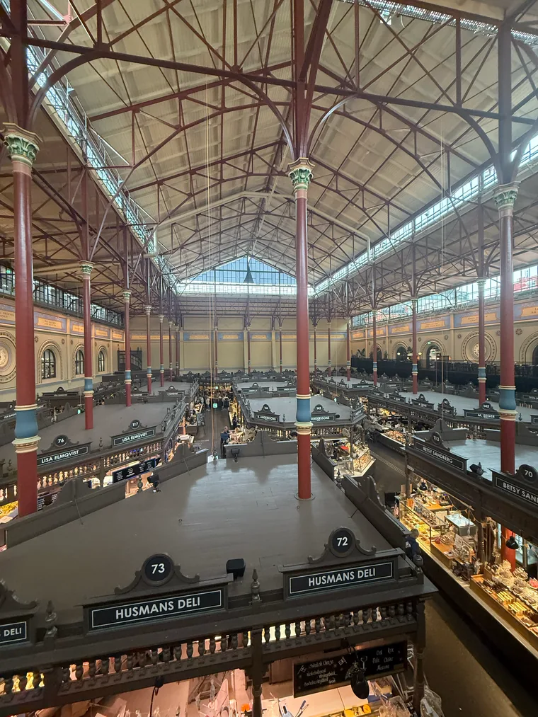 Innenraum der Östermalms Saluhall mit gusseisernen Säulen und Marktständen