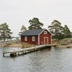 Falunrotes Atelier- und Werkstattgebäude mit Holzsteg auf einer kleinen Schäreninsel vor Stockholm