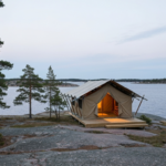 Stilvolles Safari-Glampingzelt auf flachem Granit zwischen Kiefern an der ruhigen Ostsee in den Stockholmer Schären