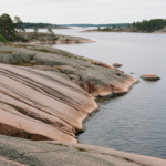 Rundgeschliffene Granitfelsen mit Gletscherschliff-Spuren am Wasser in den Stockholmer Schären